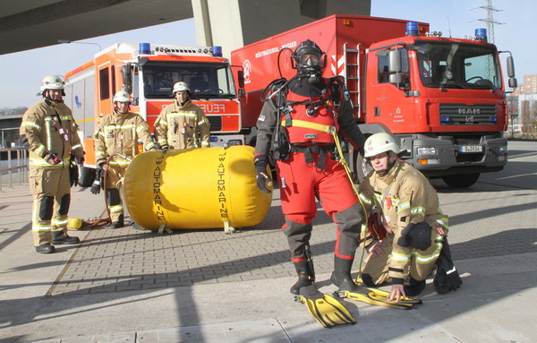 Feuerwehrleute mit Tauchausrüstung und Gerätewagen